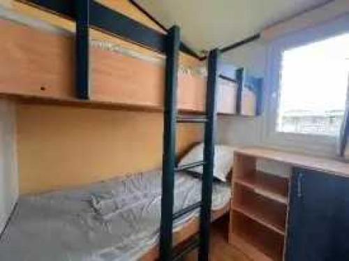 a bedroom with two bunk beds and a desk at Camping 3 étoiles - efaicg in Auxonne