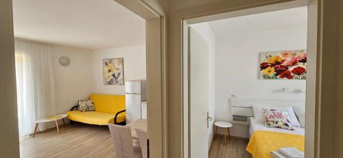 a living room with a yellow couch in a room at Cina Apartments in Cavtat