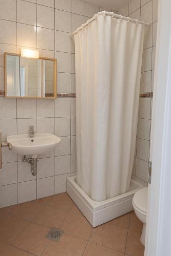 a bathroom with a shower curtain and a sink at Marika Seaside Apartments Drašnice Sea View, Parking & Near Beach in Drasnice