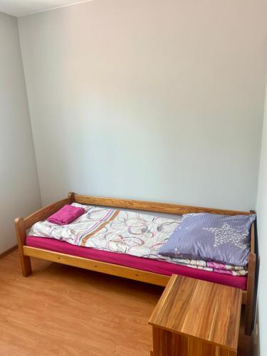 a small bed with a wooden frame in a room at Zajazd Leśny Borysławice Kościelne in Borysławice Kościelne