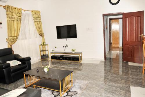 a living room with a couch and a tv at Luxury Spacious Apartment in Kumasi