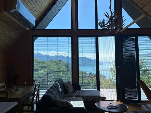 a living room with a couch and a large window at Cottage KOLKHA in Sarpi