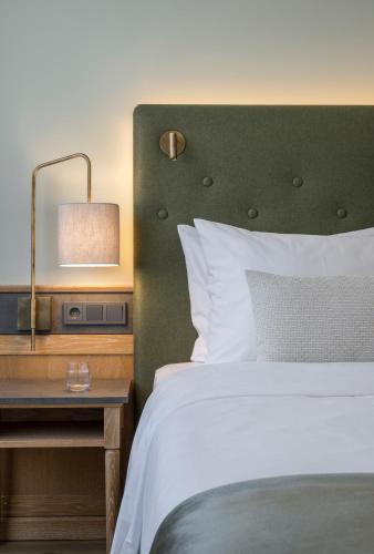 a bedroom with a bed and a table with a lamp at Hotel IMLAUER & Bräu in Salzburg