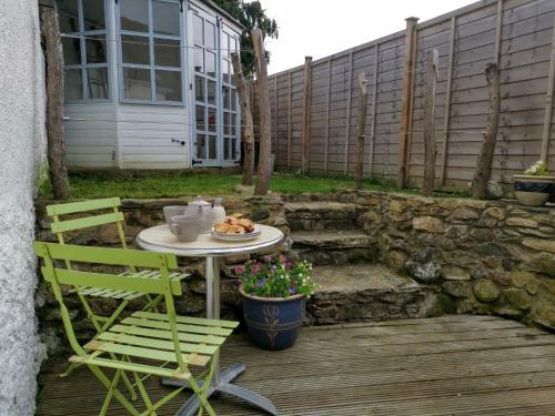 a table with a plate of food on a patio at the Nook, Romantic cottage for two, Dartmoor and SW coast in Bovey Tracey