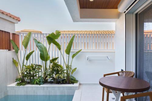 a room with a table and some plants at Palm Boutique Suites in Pefkohori