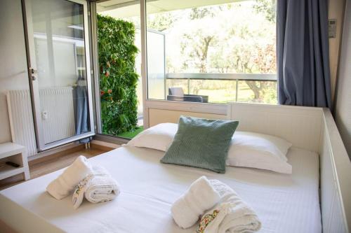 - une chambre avec un lit, des serviettes et une fenêtre dans l'établissement Beautiful vacation apartment - Swimming pool - Parking, à Antibes