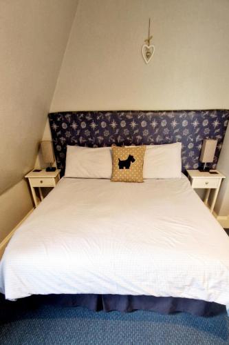 a bedroom with a large white bed with a headboard at Harbour bridge, Camps bar in Wick