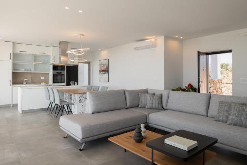 a living room with a gray couch and a table at Margaret Villa - Pool, Heated Spa Whirlpool & BBQ, By ThinkVilla in Angeliana