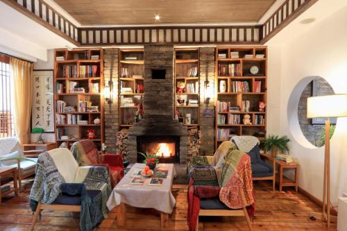 a living room with a fireplace and bookshelves at Mild Spring Boutique Hotel in Huangshan