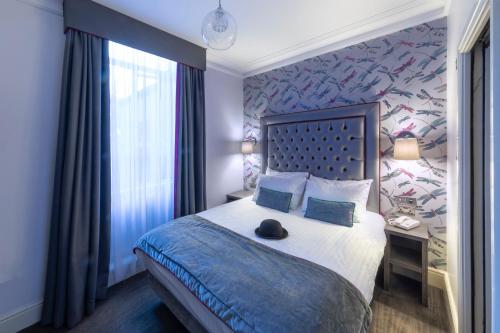 a hotel room with a bed and a desk at The Beverley Hotel London - Victoria in London