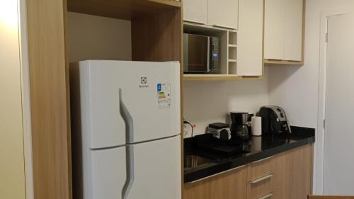 a kitchen with a white refrigerator in a kitchen at Studio 803 in Marília