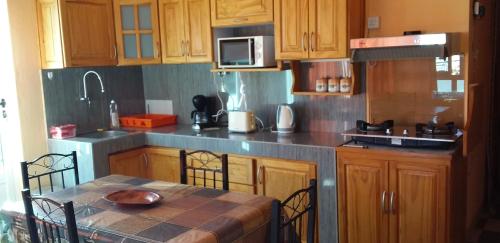 Una cocina con gabinetes de madera y una mesa con sillas. en Flamengo Apartment, en Midlands Station