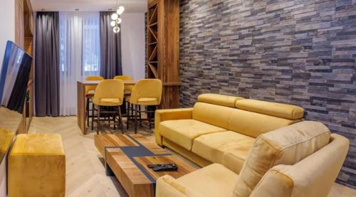 a living room with a couch and a table at Apartment IB Studio Aparthotel Poljice in Jahorina