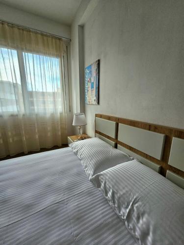 a bedroom with two beds and a large window at Vlora Beach Apartment Orikum in Orikum