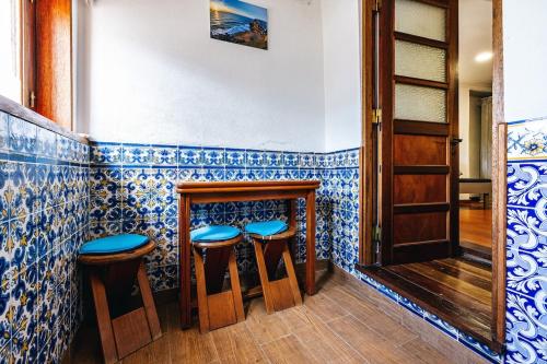 - un bar avec des murs et des tabourets en carrelage bleu et blanc dans l'établissement Private, romantic and cozy Room in Azenhas do Mar, à Colares