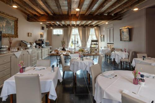 ein Restaurant mit Tischen und Stühlen in einem Raum in der Unterkunft Martin's Relais in Brügge