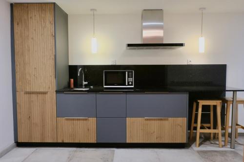 a kitchen with a black counter and a microwave at Versant de vigne in Chalon-sur-Saône