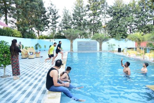 a group of people playing in a swimming pool at Aroma Green Farm Manesar with Pool in Bahora