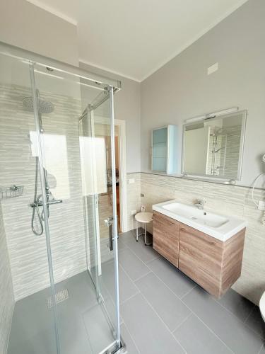 a bathroom with a sink and a glass shower at Ville Paola e Daniela in San Vincenzo