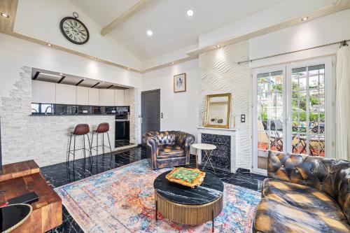 Elle comprend un salon doté d'un mobilier en cuir et d'une cheminée. dans l'établissement Villa Nissarda, Maison Niçoise avec vue mer, parking, à 5 minutes du port, à Nice