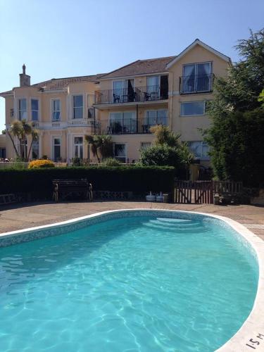 a large blue swimming pool in front of a building at Nethway Hotel in Torquay