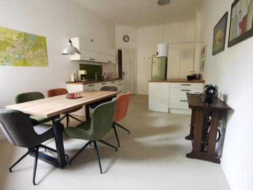 a kitchen and dining room with a wooden table and chairs at Ferienwohnung Potsdam in Potsdam