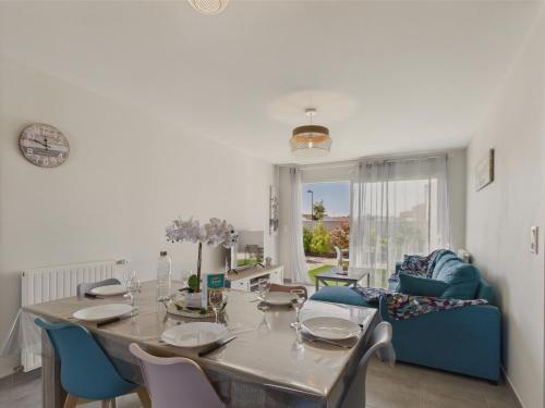 une salle à manger avec une table et des chaises bleues dans l'établissement Jolie maison pour 6 avec jardin, à Saint-Vincent-sur-Jard