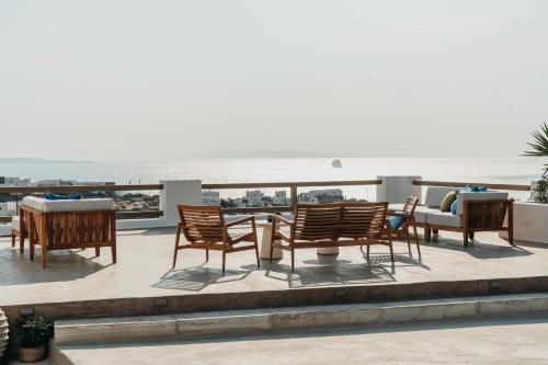 a group of chairs and tables on top of a roof at Athera Suites Mykonos in Tagou
