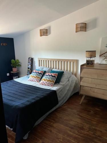 a bedroom with a bed and a wooden dresser at Villa Valent in Cazilhac