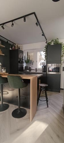 a kitchen with a large wooden table with a green chair at Comfortable, cozy house 20 min to Amsterdam in Zaandam