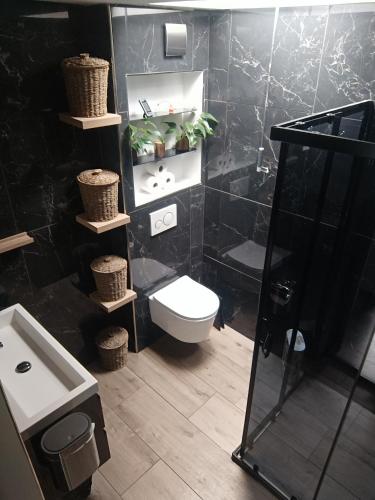 a black bathroom with a toilet and a sink at Comfortable, cozy house 20 min to Amsterdam in Zaandam
