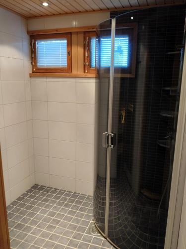 a shower with a glass door in a bathroom at Salmikangas G4 in Ruka