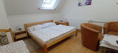 a bedroom with a bed and two chairs at Penzión Veperec in Hokovce