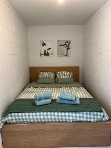 une chambre avec un grand lit avec des oreillers bleus dans l'établissement Le cottage, à Canapville