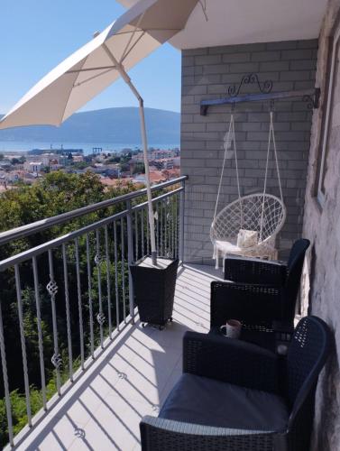 a balcony with two chairs and an umbrella at Bella Casa in Bijela