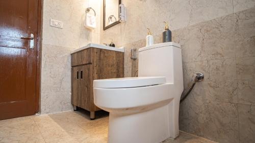 Un baño con un inodoro blanco en una habitación. en Dhrisha Mohatsav By Alcor, en Manali