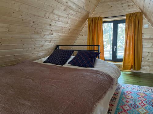 a bedroom with a bed in a log cabin at Casa Boema- La noi la munte in Mătişeşti