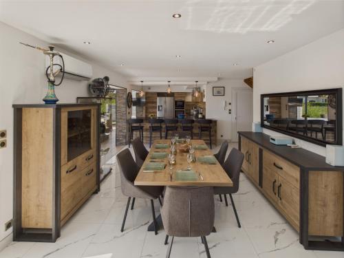 a dining room with a table and some chairs at Piscine, jacuzzi et grande terrasse pour 7 in Penmarcʼh
