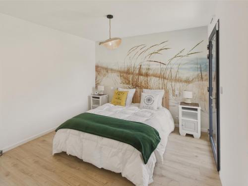 une chambre avec un lit et un tableau au mur dans l'établissement Maison neuve à 600m de la plage pour 8, à Loctudy