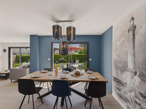 une salle à manger avec une table et des chaises en bois dans l'établissement Maison neuve à 600m de la plage pour 8, à Loctudy