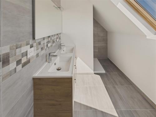 une salle de bains mansardée avec un lavabo et un escalier. dans l'établissement Maison neuve à 600m de la plage pour 8, à Loctudy