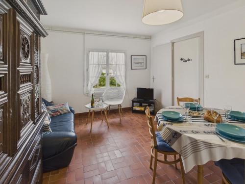 un salon avec une table et un canapé dans l'établissement La Corvette - Pour 4 dans une chaumière avec jardin, au Guilvinec