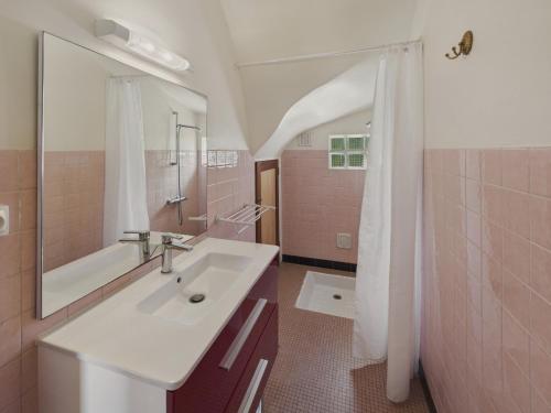 une salle de bain avec un lavabo, une baignoire et un miroir dans l'établissement La Corvette - Pour 4 dans une chaumière avec jardin, au Guilvinec