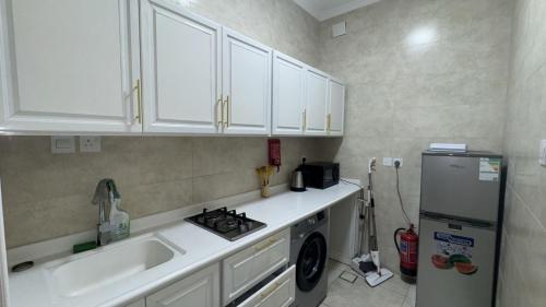 a kitchen with a sink and a stove and a refrigerator at شقة لين طيبة للعوائل Leen Taibah Ap. for family's in Al Madinah