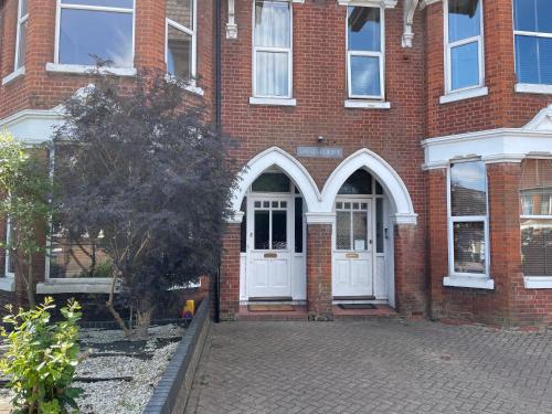 a brick building with a white door on a street at Number 10 service apartment - Danes in Southampton