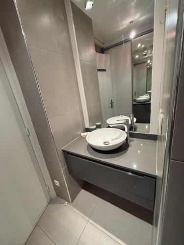 une salle de bain avec un lavabo et un miroir dans l'établissement Appartement Suffren Champs de Mars, à Paris