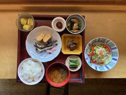 a table with plates of food and bowls of food at パライソ梅田 in Ise