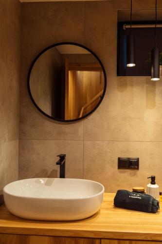 a bathroom with a white sink and a mirror at Świerkowe Chatki w Koniakowie in Koniaków