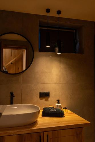 a bathroom with a sink and a mirror at Świerkowe Chatki w Koniakowie in Koniaków