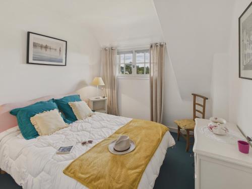 une chambre avec un lit avec un chapeau dessus dans l'établissement La Frégate - Dans une chaumière pour 4 avec jardin, au Guilvinec